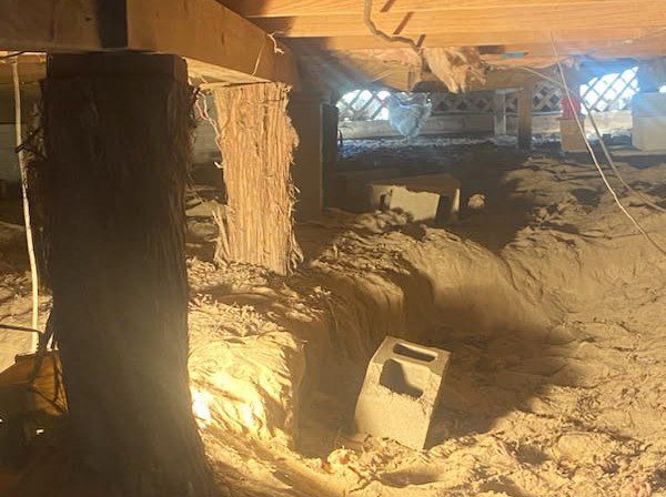 A large pile of sand in the middle of an unfinished room.